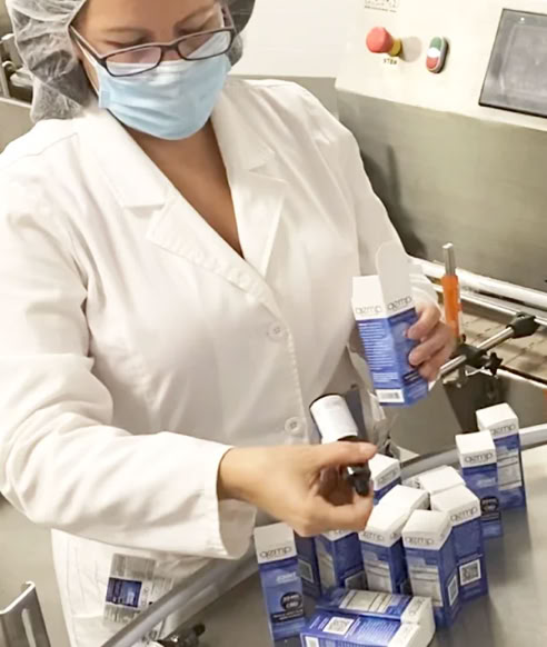 Quality control inspector examining finished beverage bottles at Nutrition Labs in Clearwater Florida